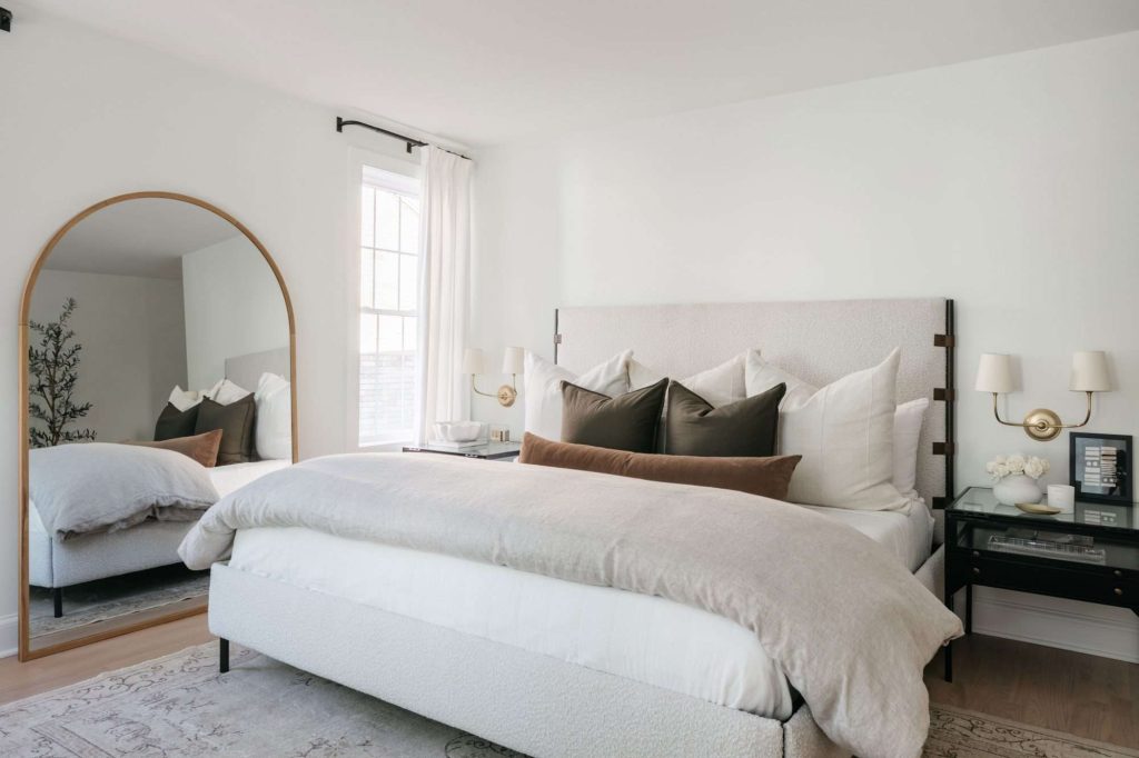 A peaceful bedroom with soft lighting, fluffy pillows, and cozy blankets.