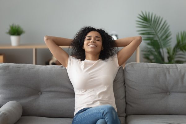 A person practicing deep breathing with eyes closed and a relaxed expression.