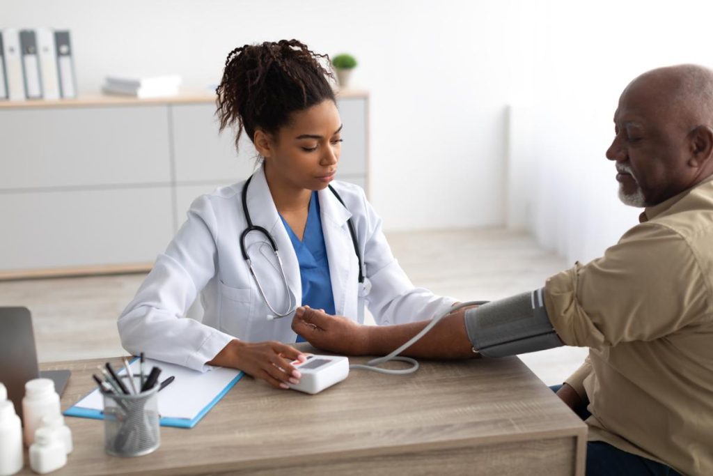 An image of a doctor checking a patient's blood pressure.